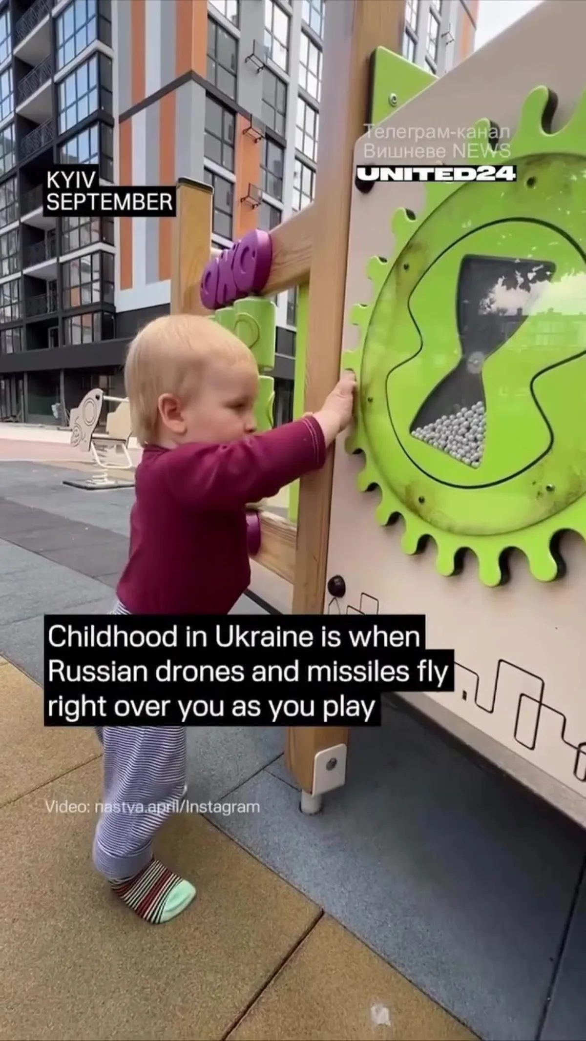 Дитина грає на дитячому майданчику біля будівель міста