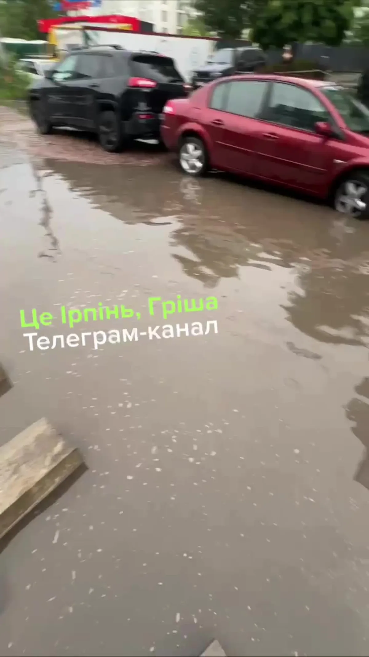 Затоплена вулиця з припаркованими автомобілями після дощу
