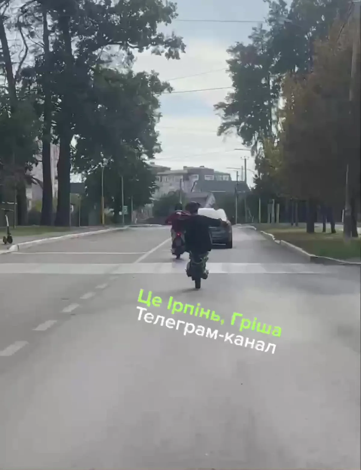 Мотоцикліст без шолома їде по дорозі міста