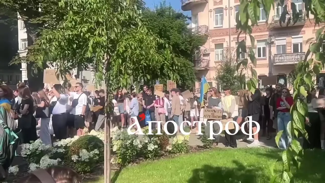 Люди на площі біля будівлі з написом