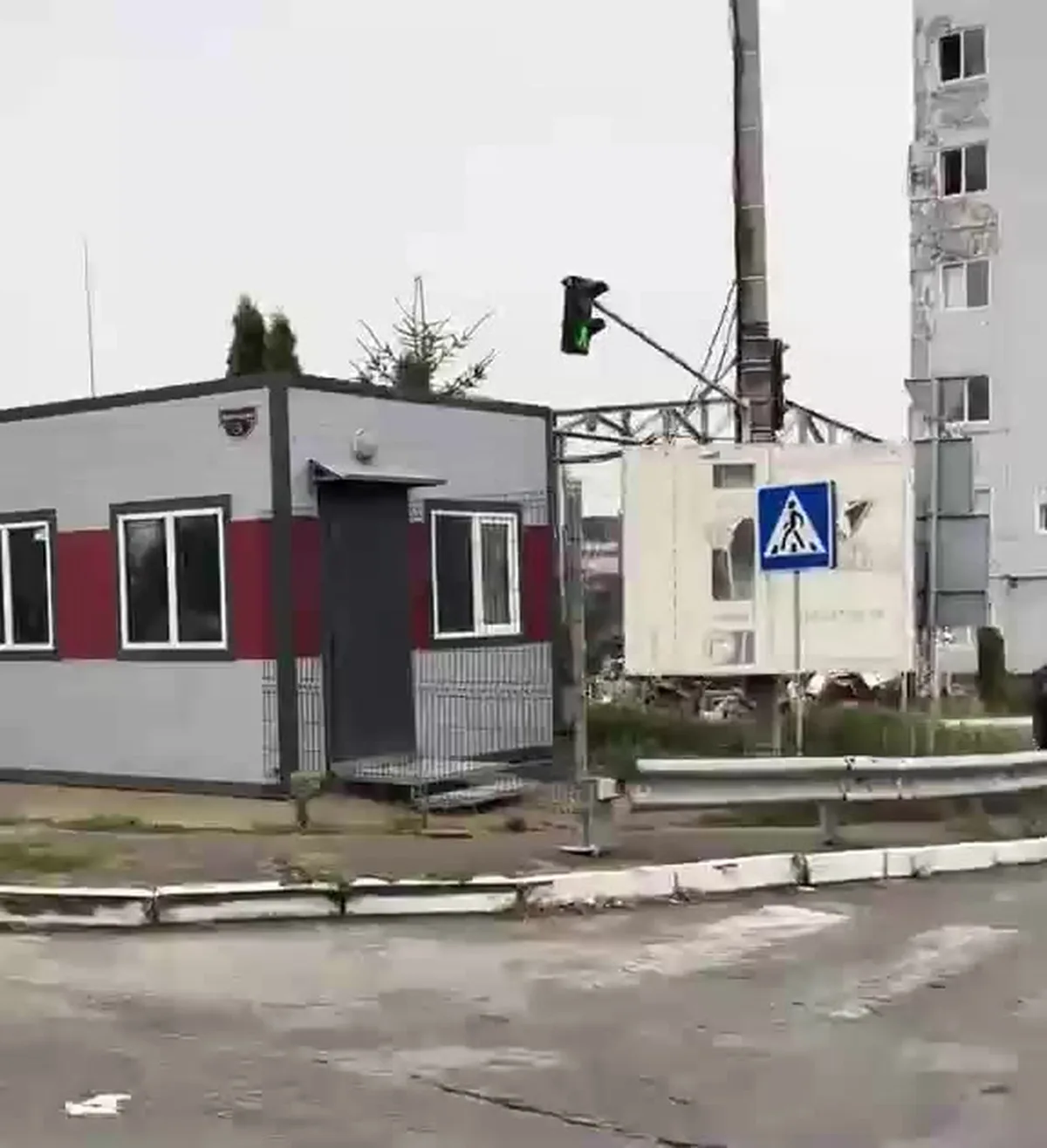 Невеликий модульний будинок біля багатоповерхівки та дорожного знака