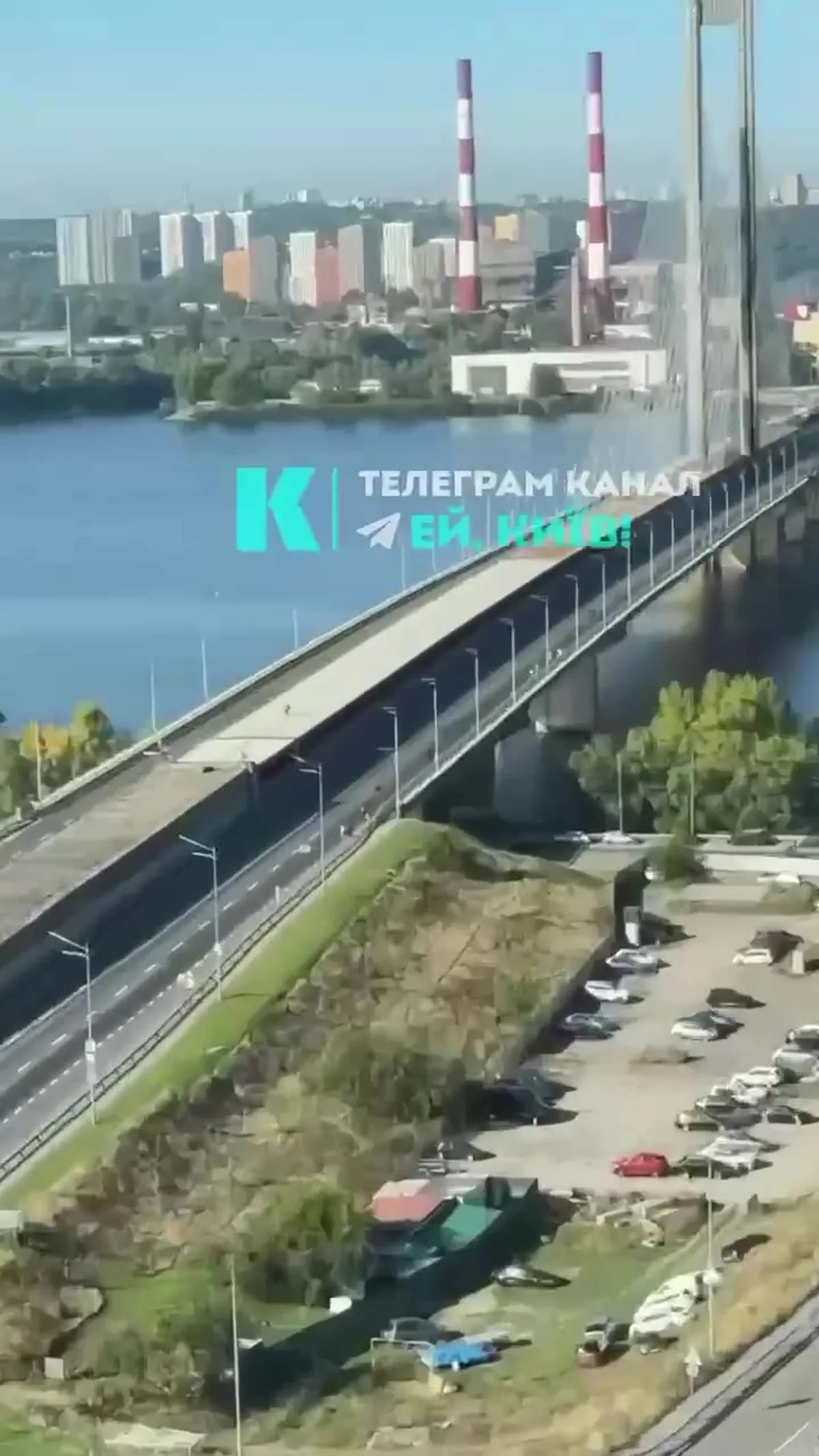Вид з висоти на міст через річку з припаркованими автомобілями внизу