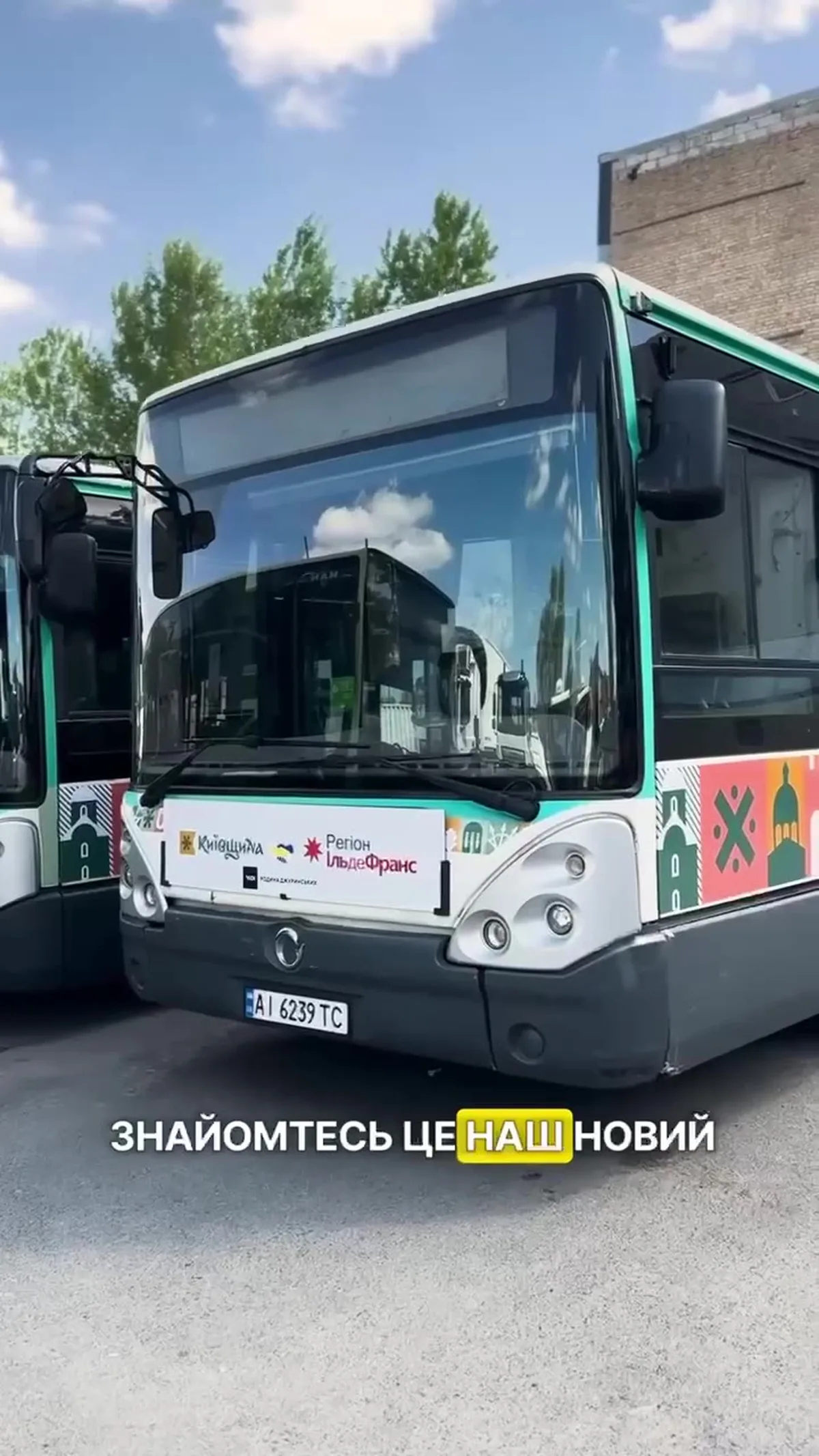 Білий автобус з написом на борту, припаркований на вулиці