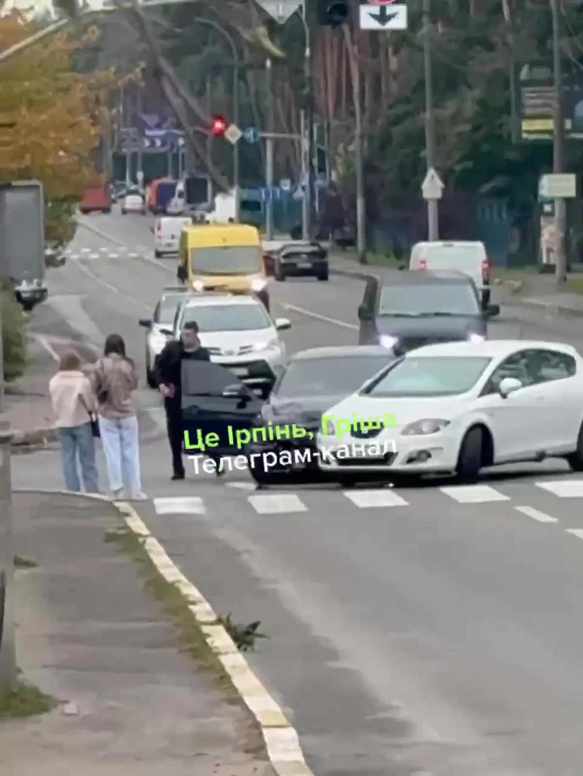 Люди на пішохідному переході серед автомобілів на вулиці