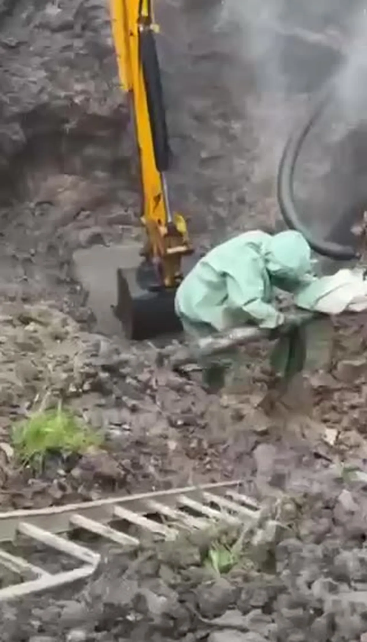 Робітник проводить ремонт водопровідної труби екскаватором