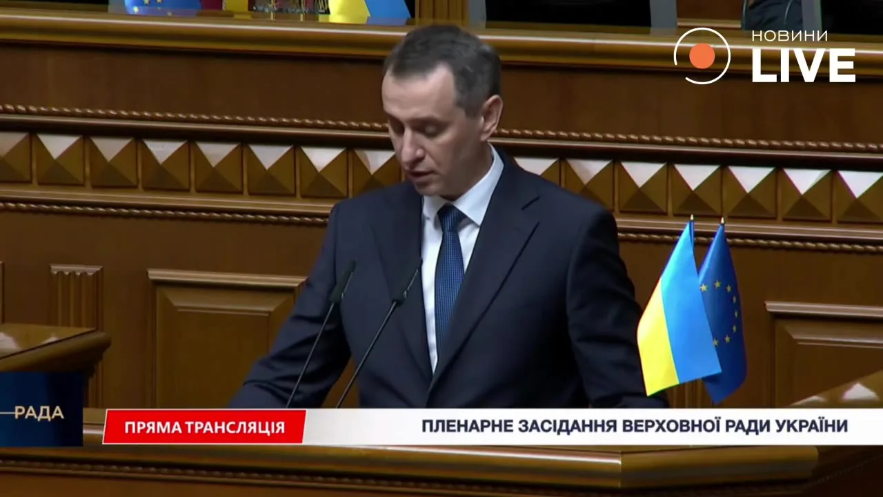 Чоловік у костюмі виступає в залі парламенту