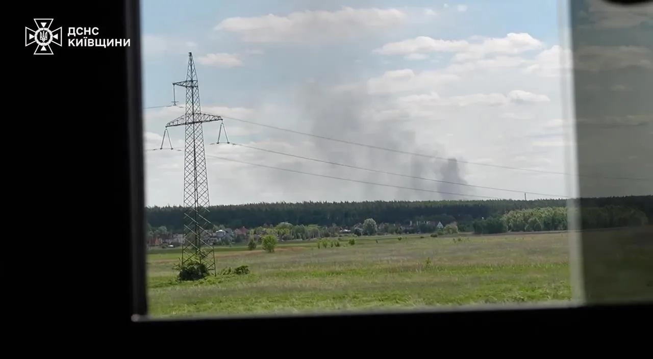Електропередавальна вежа в полі, дим у далечині
