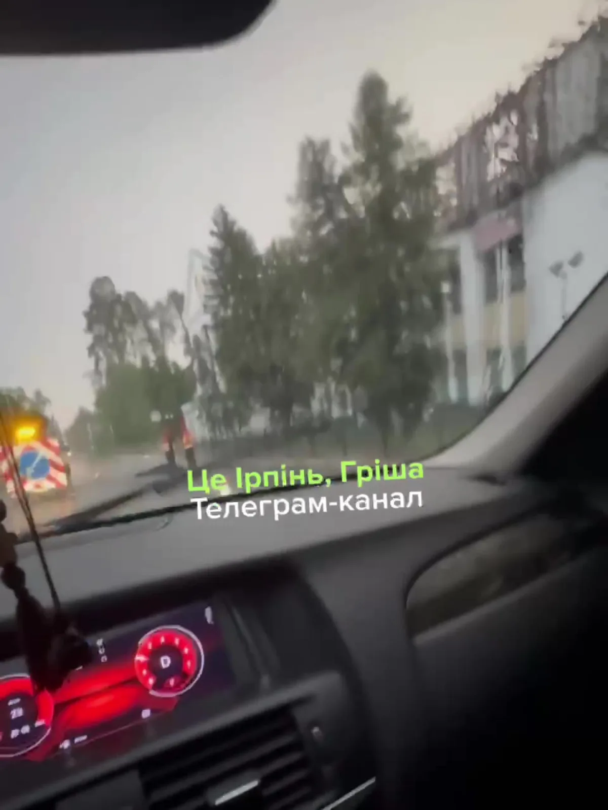 Вид з салону автомобіля на вулицю з деревами та будівлями