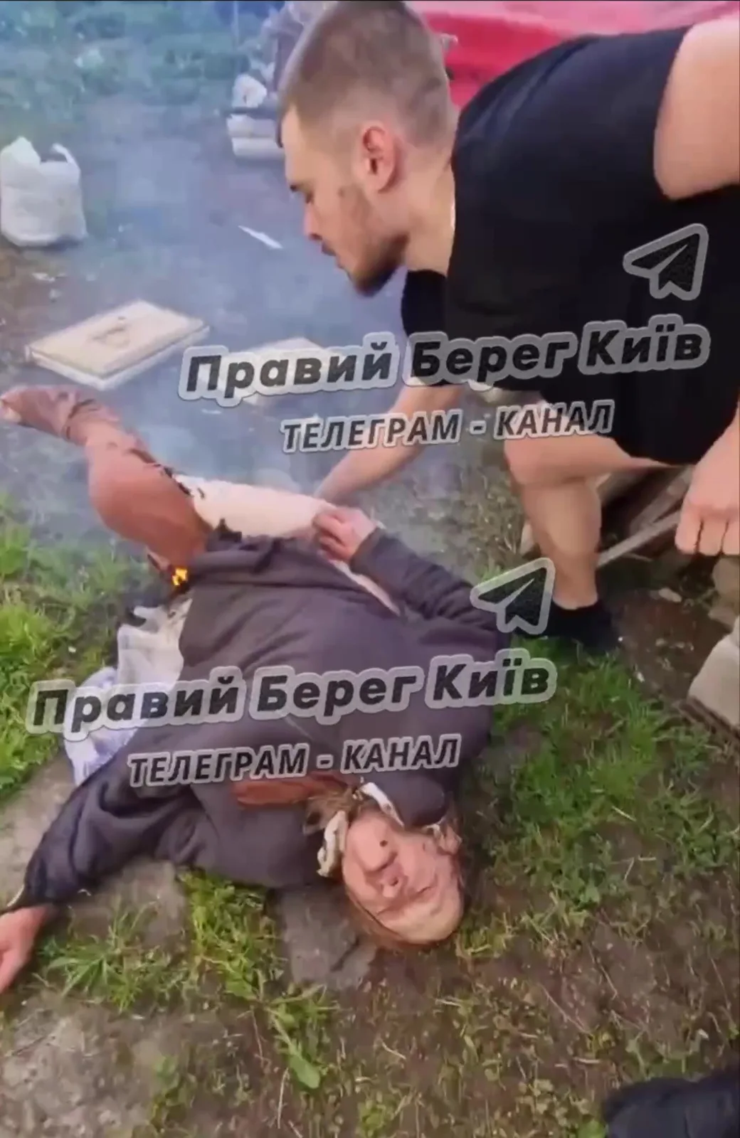 Чоловік надає першу допомогу літній жінці на землі
