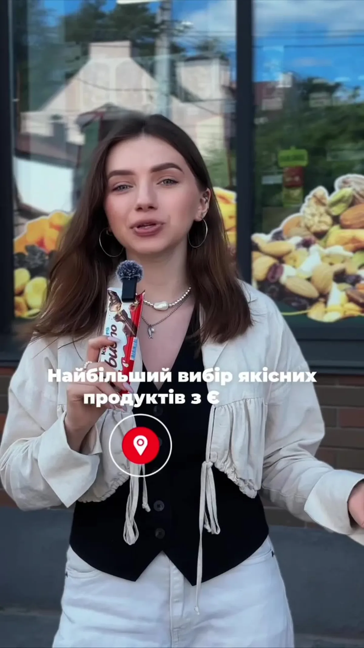 Жінка з мікрофоном біля вітрини магазину