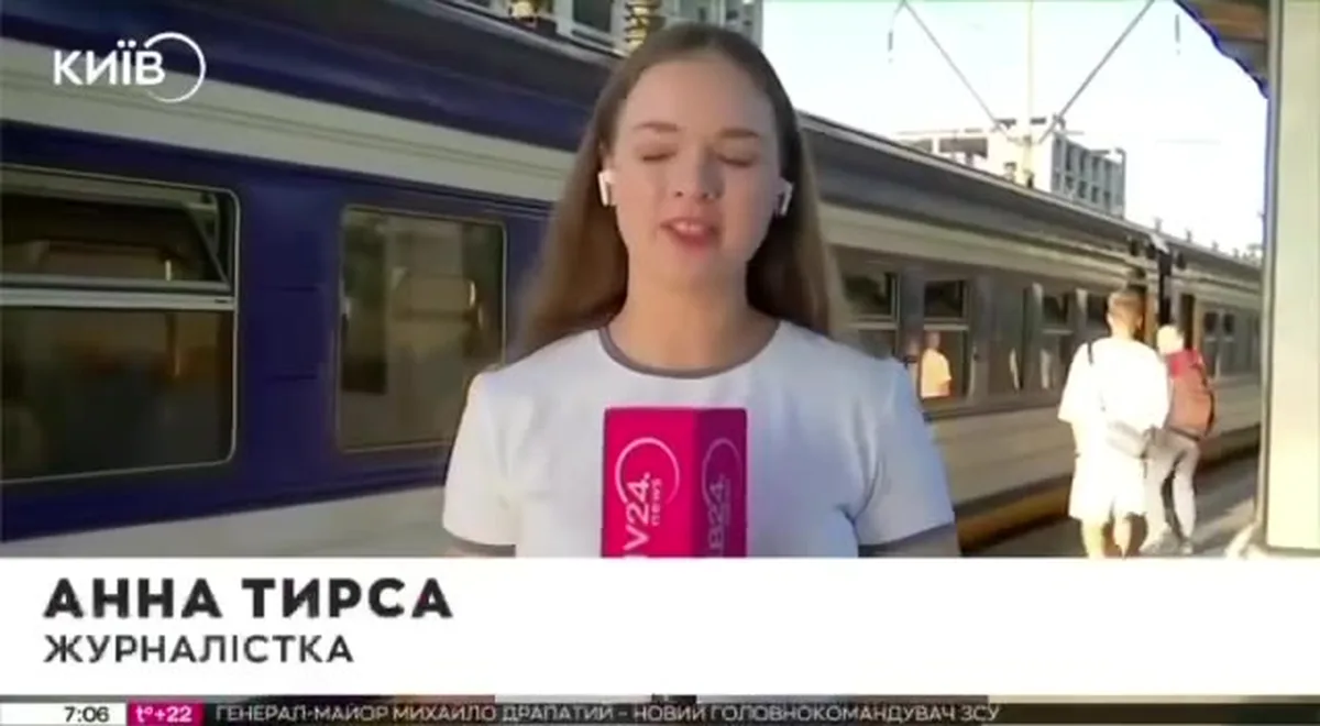 Журналістка зі смартфоном біля поїзда метро