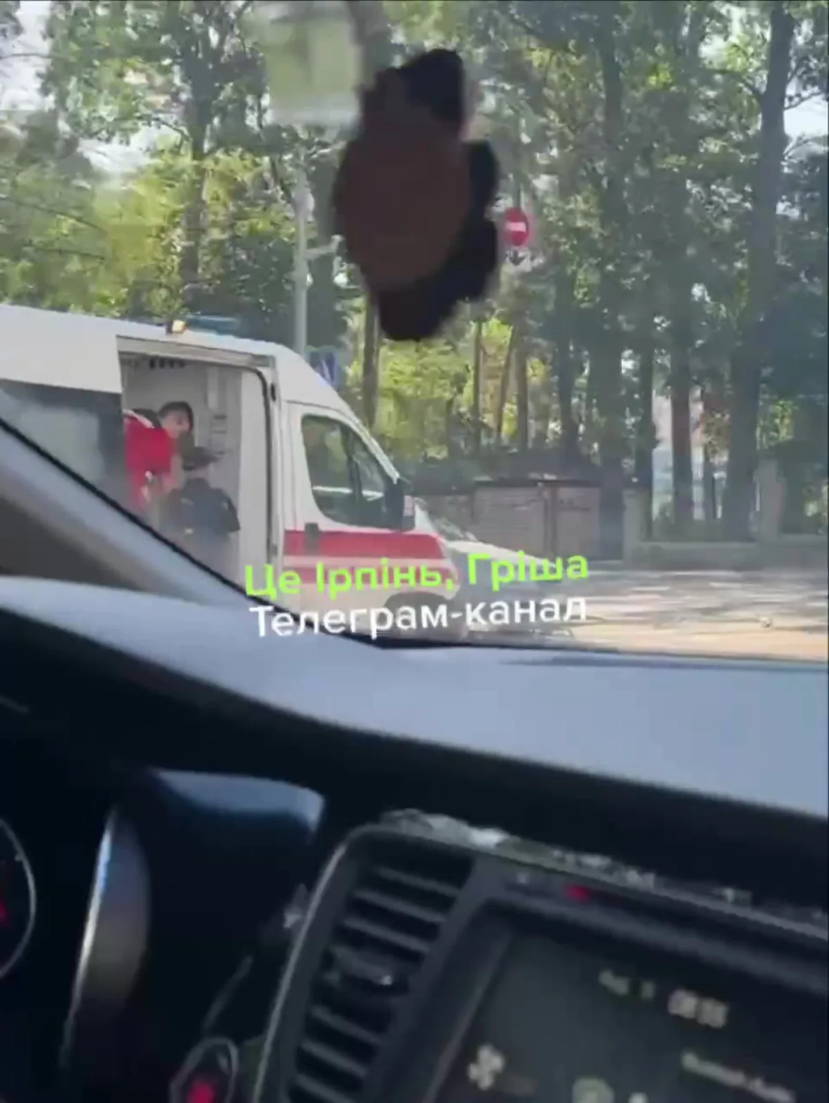 Вид з салону автомобіля на вулицю з деревами
