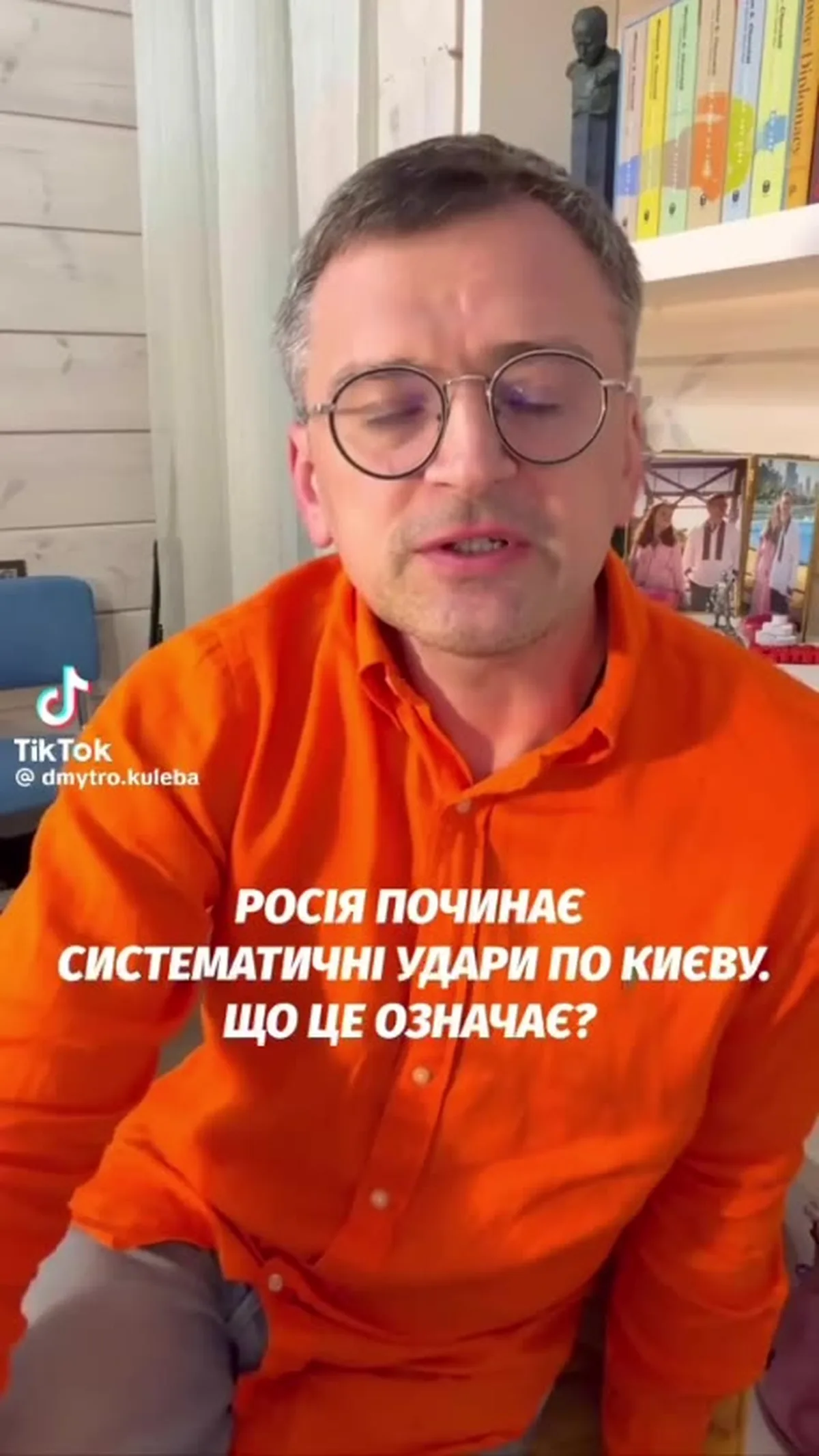 Чоловік у помаранчевій толстовці в домашньому інтер'єрі