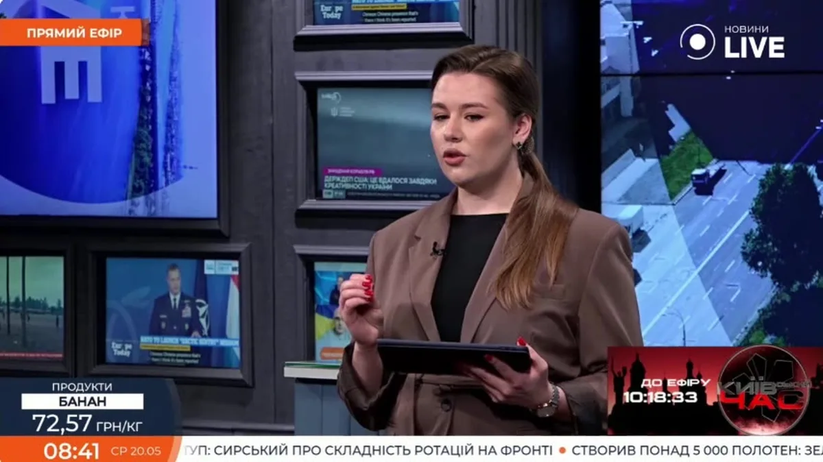 Жінка в студії телеканалу з планшетом в руках під час прямого ефіру