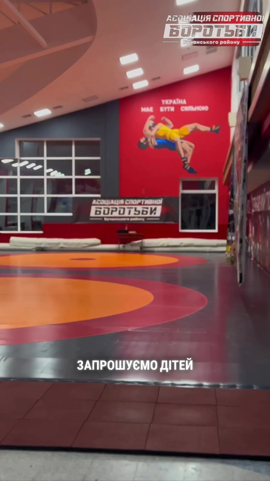 Інтер'єр спортивного залу з червоною стіною та логотипом клубу