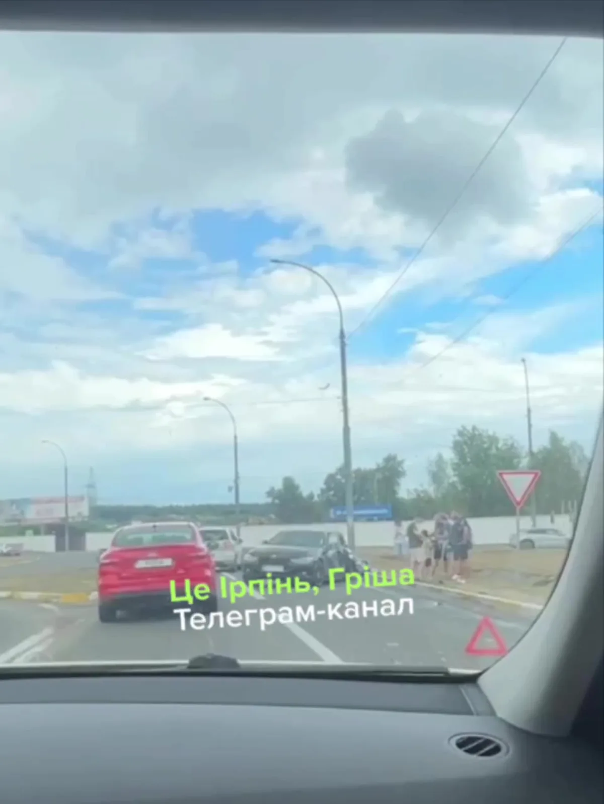 Вид з салону автомобіля на дорожне кільце з червоним авто