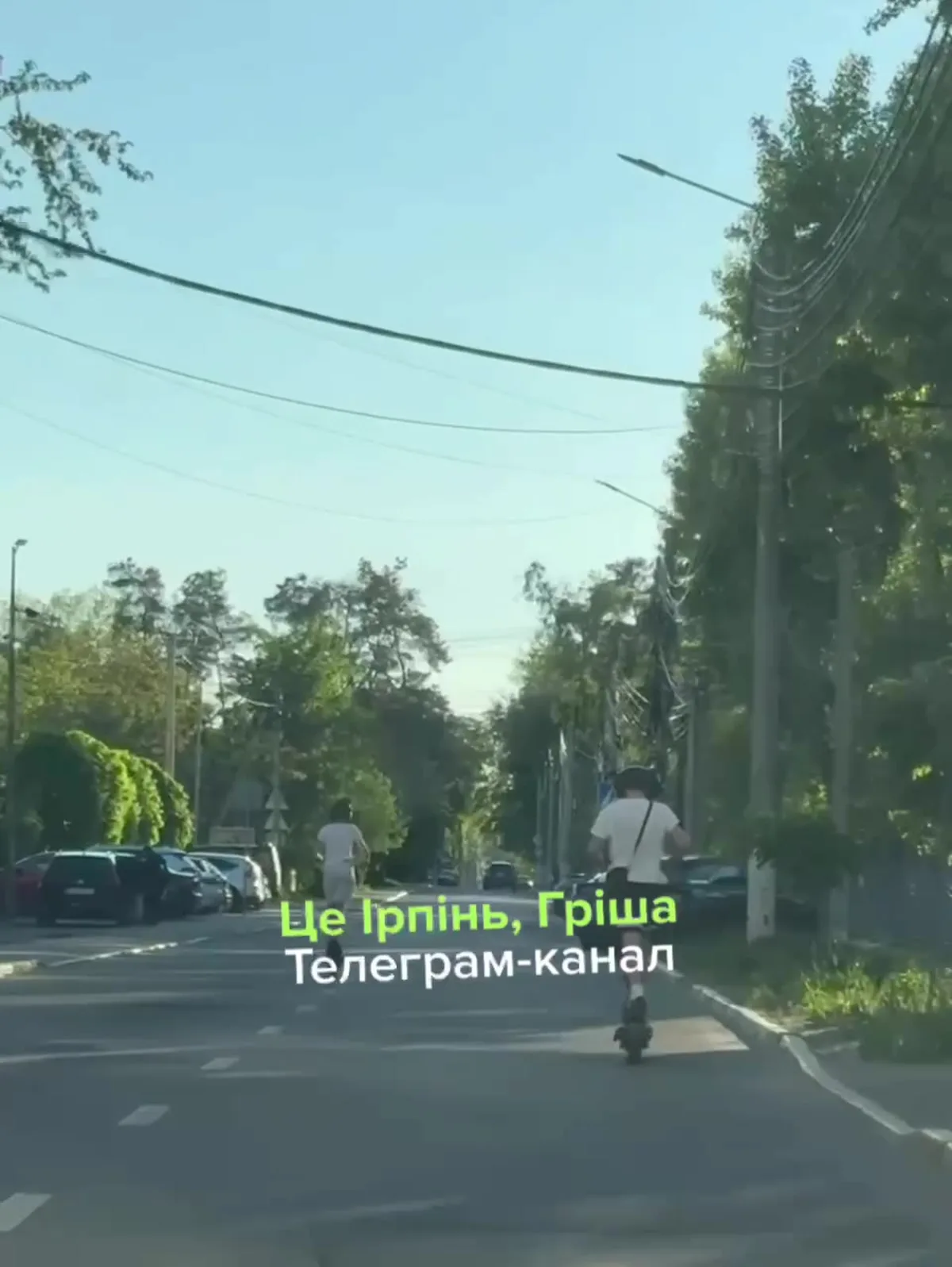 Людина на електросамокаті їде вулицею Ірпеня