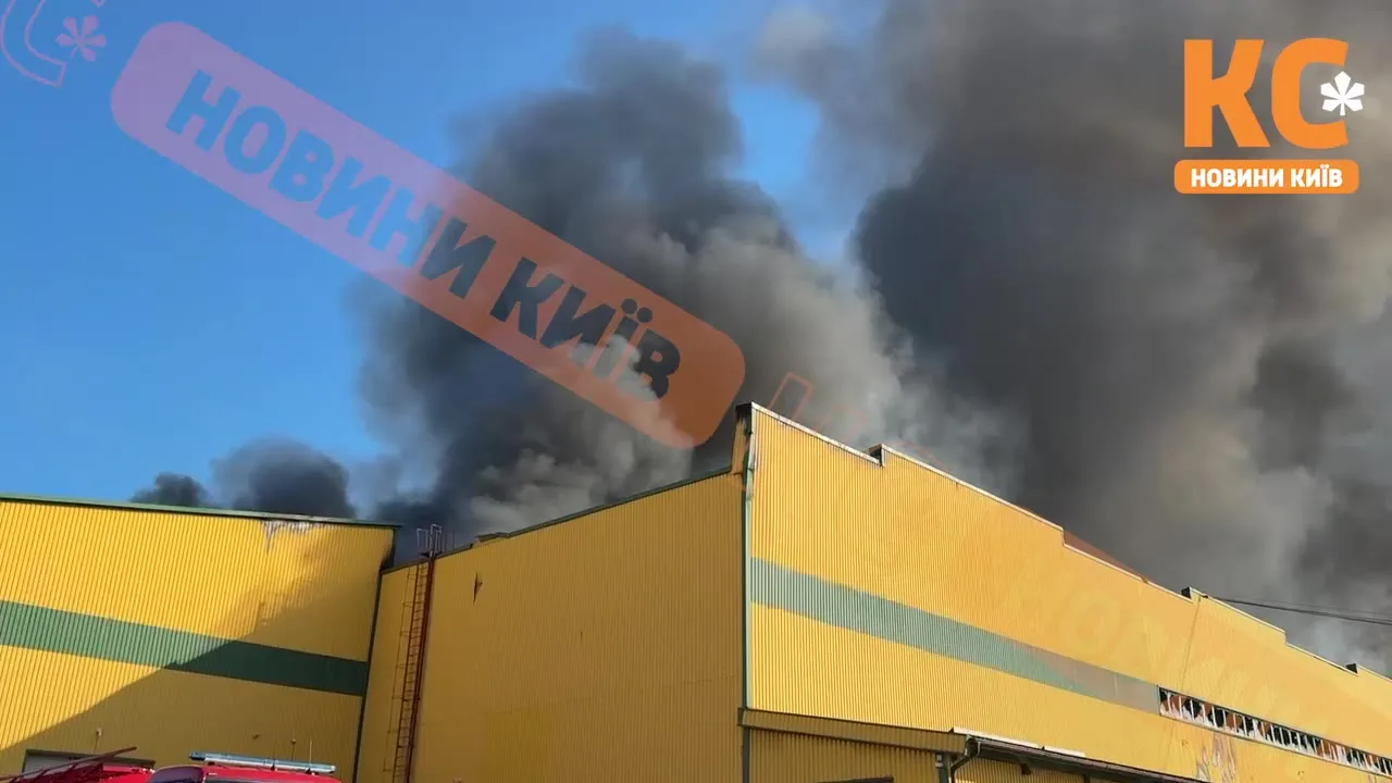 Дим над жовтою будівлею складу під час пожежі