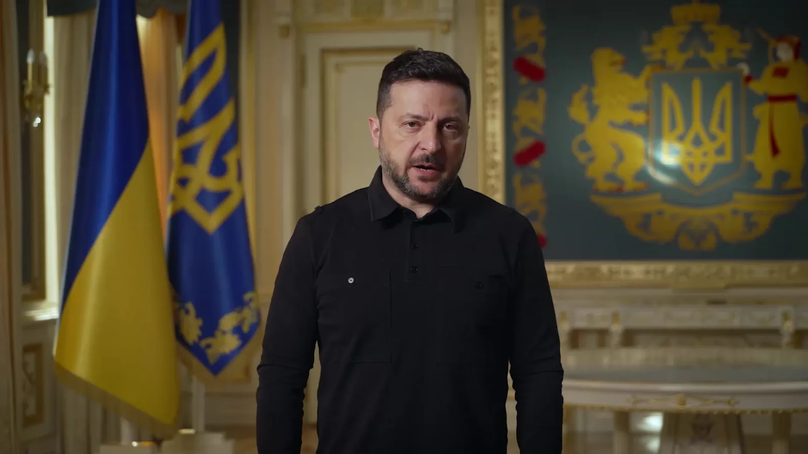 Чоловік у чорній сорочці на тлі українського прапора