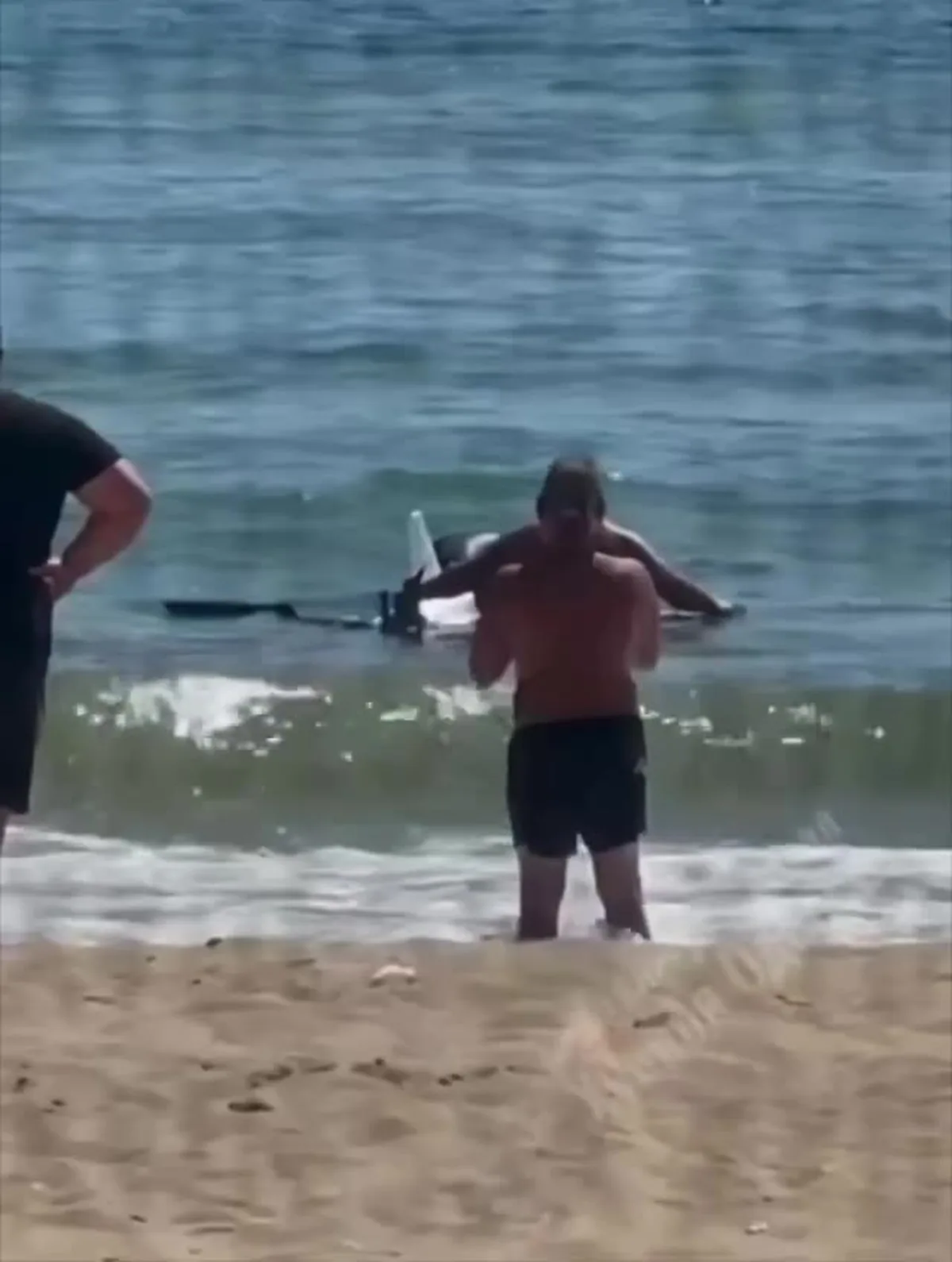 Люди на пляжі біля збитого безпілотника у воді