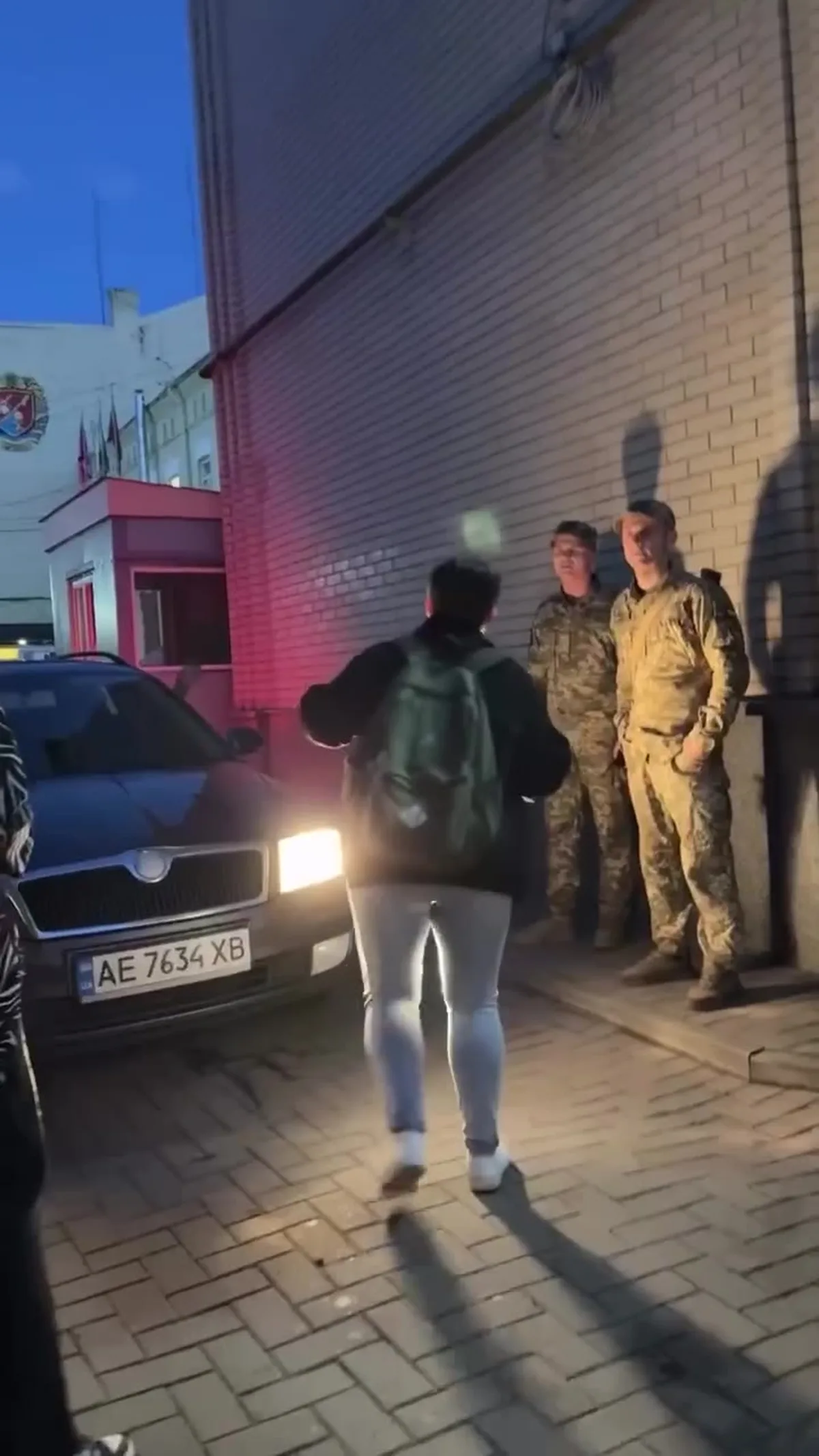 Люди біля припаркованого автомобіля вночі на вулиці