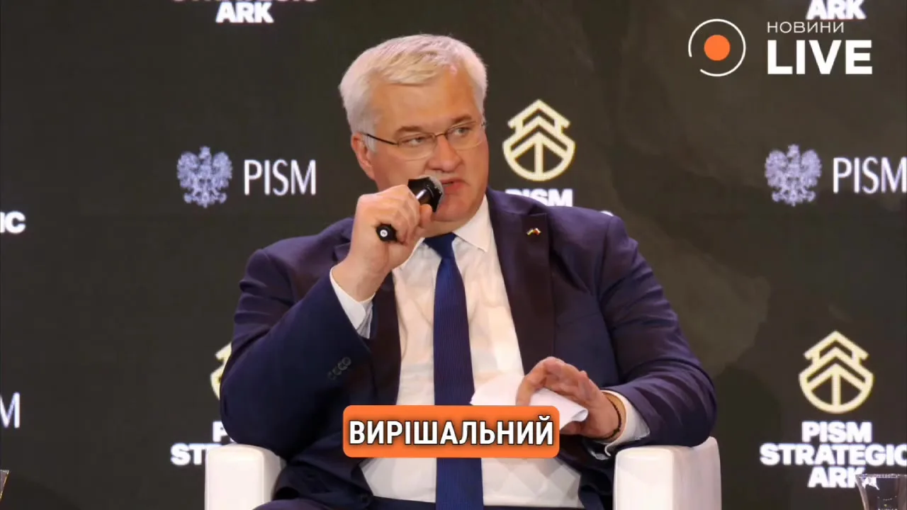 Чоловік у костюмі говорить до мікрофона на конференції