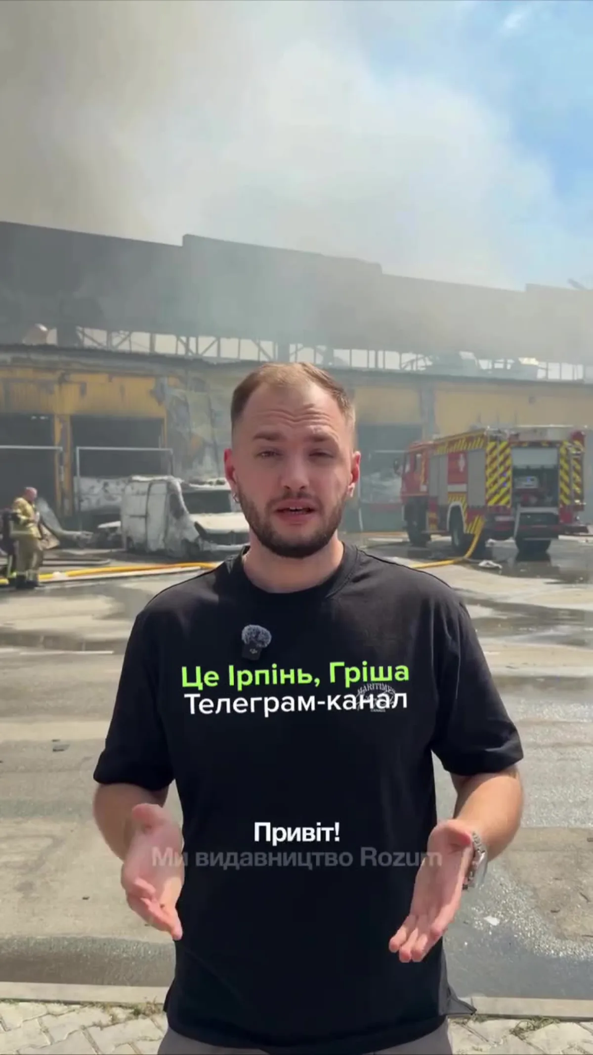 Чоловік у чорній футболці на тлі пошкодженої будівлі