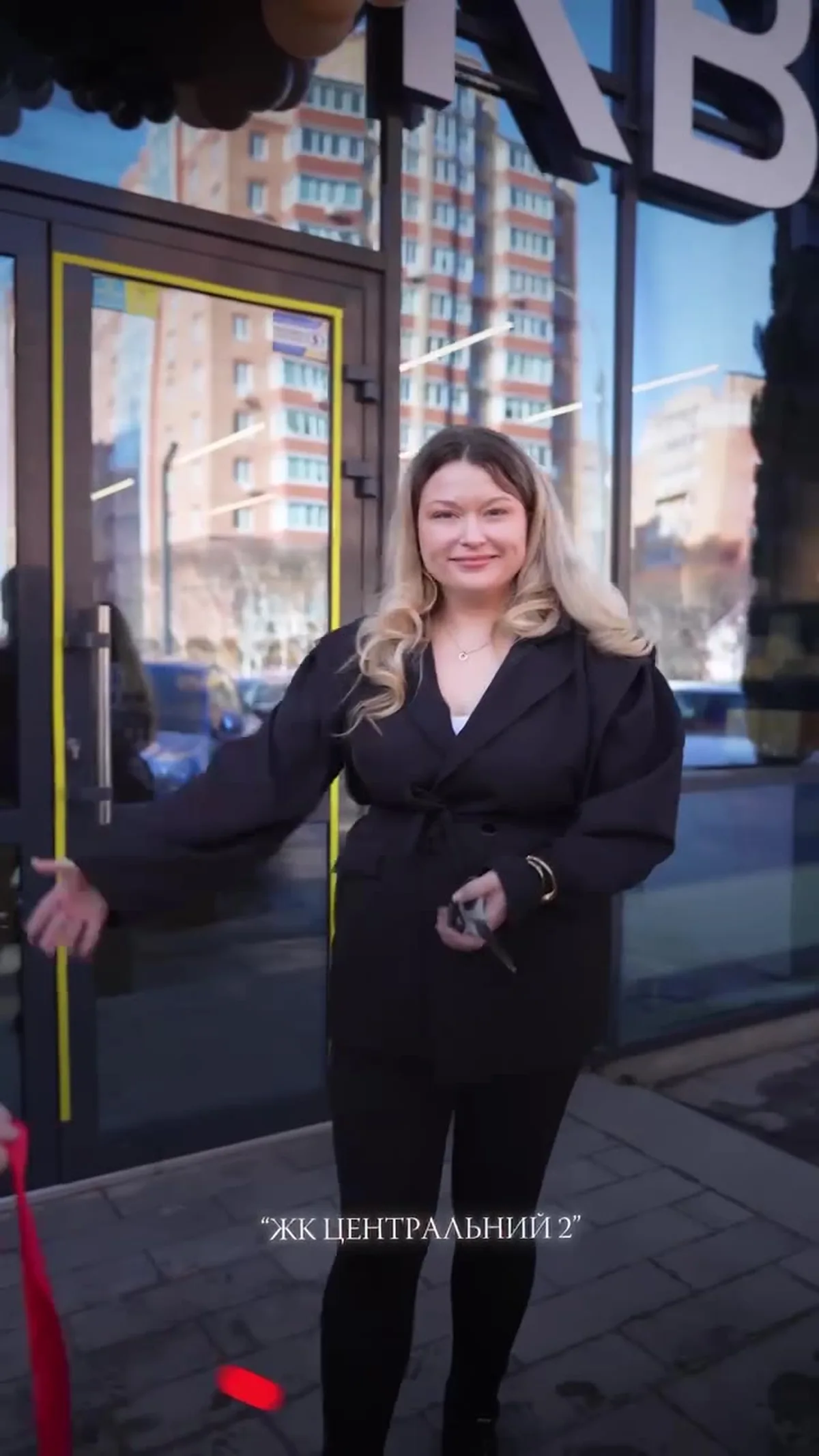Жінка біля входу до магазину на вулиці міста