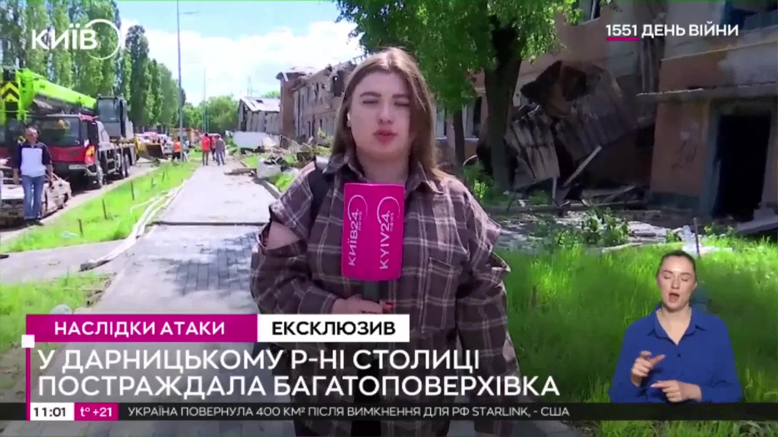 Журналістка в клітчастій сорочці біля пошкодженої будівлі гуртожитку в Дарницькому районі