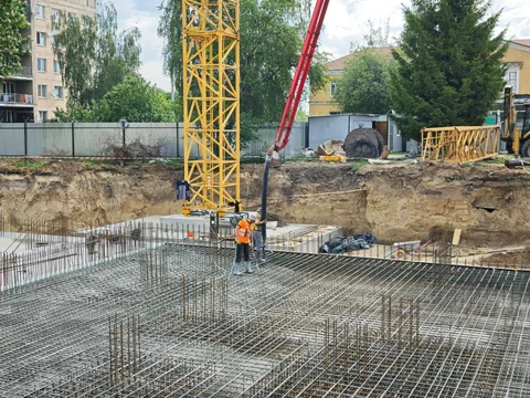 Будівельний майданчик з арматурною сіткою та кранами