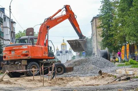 Екскаватор розвантажує щебінь на вулиці під час робіт