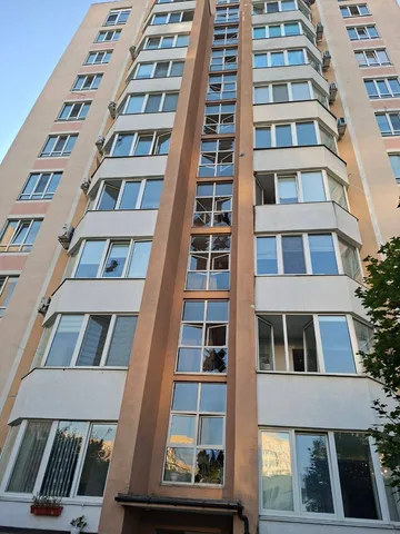 Багатоповерховий житловий будинок з пошкодженими вікнами та балконами