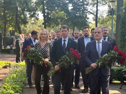 Офіційні особи з квітами на церемонії в парку
