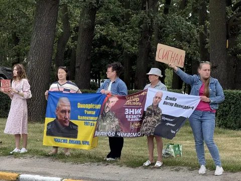 Група людей з плакатами та прапорами на акції підтримки в парку