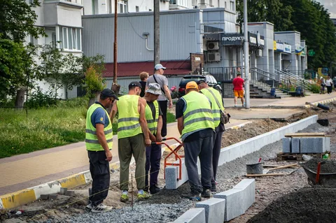 Робітники в жилетах проводять роботи на будівельному майданчику
