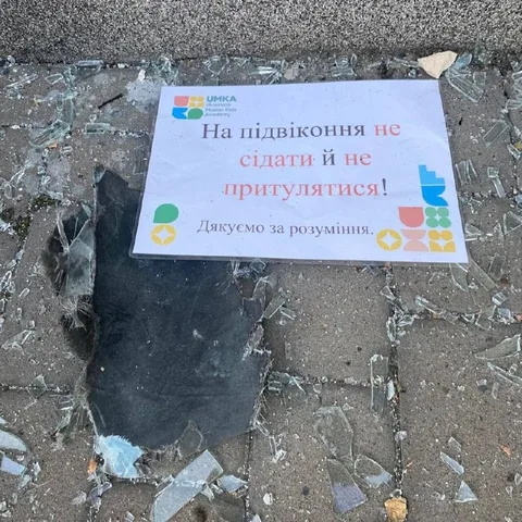 Пошкоджена табличка на асфальті біля руйнувань будівлі