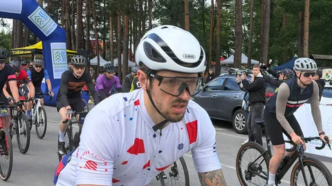 Велосипедист у білому спортивному костюмі на старті марафону
