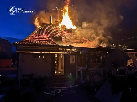 Будинок охоплений вогнем у ночі, дим піднімається вгору
