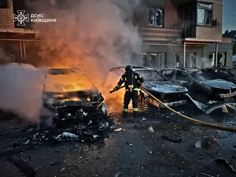 Рятувальник гасить пожежу в автомобілях на вулиці Києва