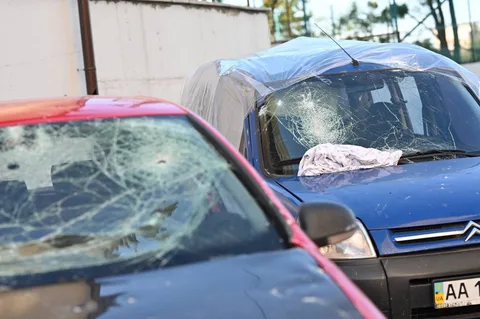 Пошкоджені автомобілі з розбитими вікнами на парковці
