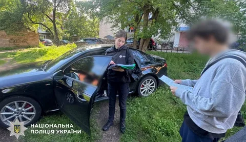Поліцейський розмовляє з чоловіком біля автомобіля