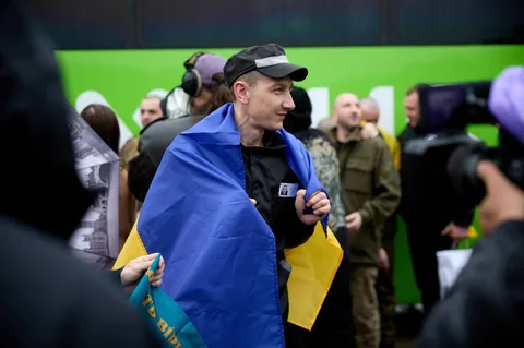 Чоловік у синьо-жовтому накидці серед людей