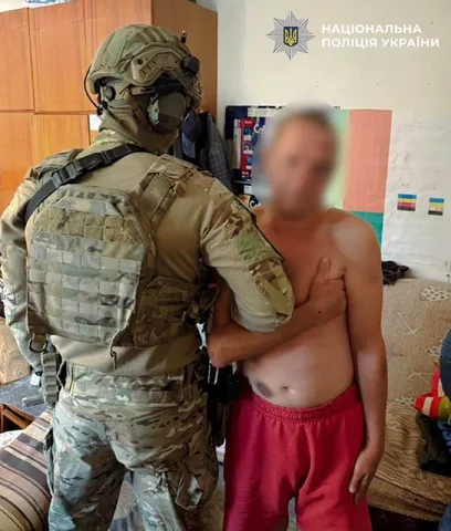 Поліцейський у військовому спорядженні затримує чоловіка в приміщенні