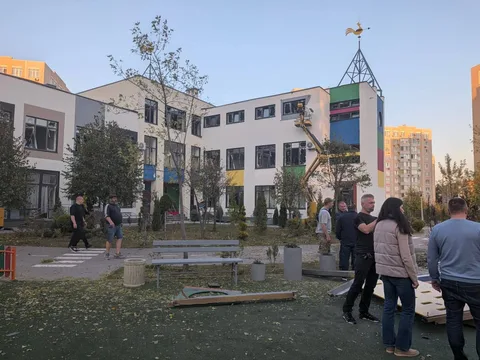Люди біля пошкодженої будівлі дитсадка в Святопетрівському