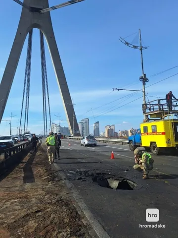 Пошкоджена дорога на мосту з вирвою, робітники в жилетах, жовтий автомобіль