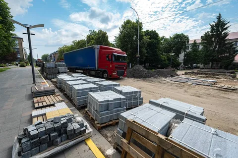 Червоний вантажний автомобіль біля будівельних матеріалів на вулиці