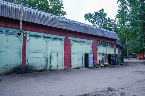 Промислова будівля з червоними стінами та гаражними воротами