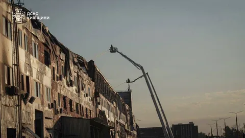 Пошкоджена багатоповерхова будівля та рятувальна техніка