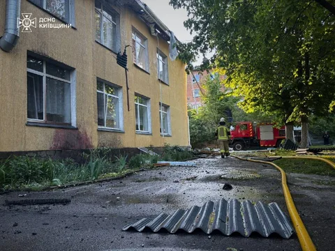 Пошкоджена будівля дитячого садка з вибитими вікнами та пожежна машина
