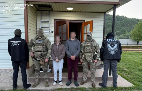 Група людей у військовому та поліцейському одязі біля будинку